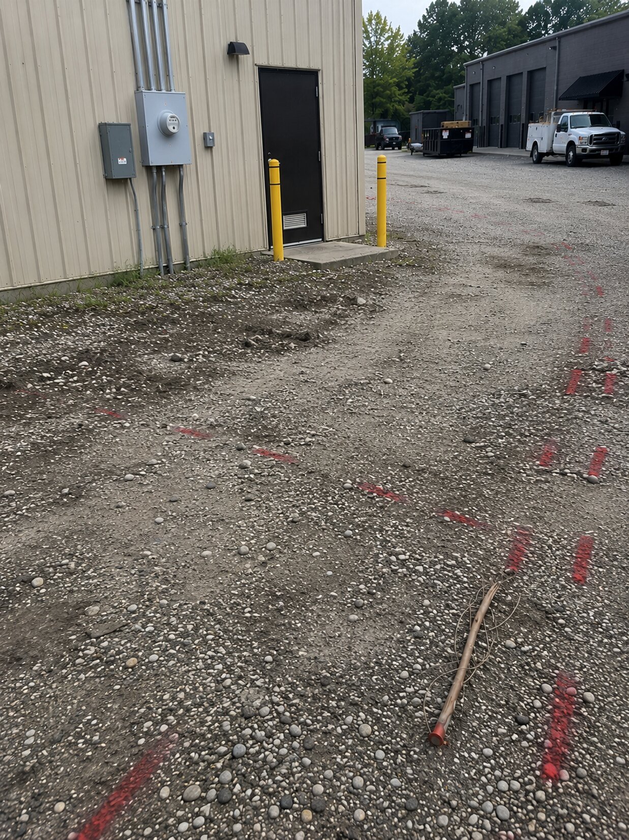 Private electric service markings traced across a commercial gravel lot